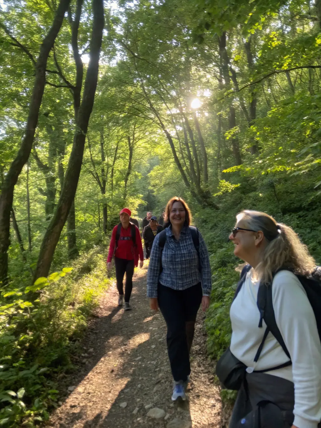 A diverse group of people participating in a guided nature walk, led by an experienced instructor, highlighting the connection with nature and the educational aspect of the program.